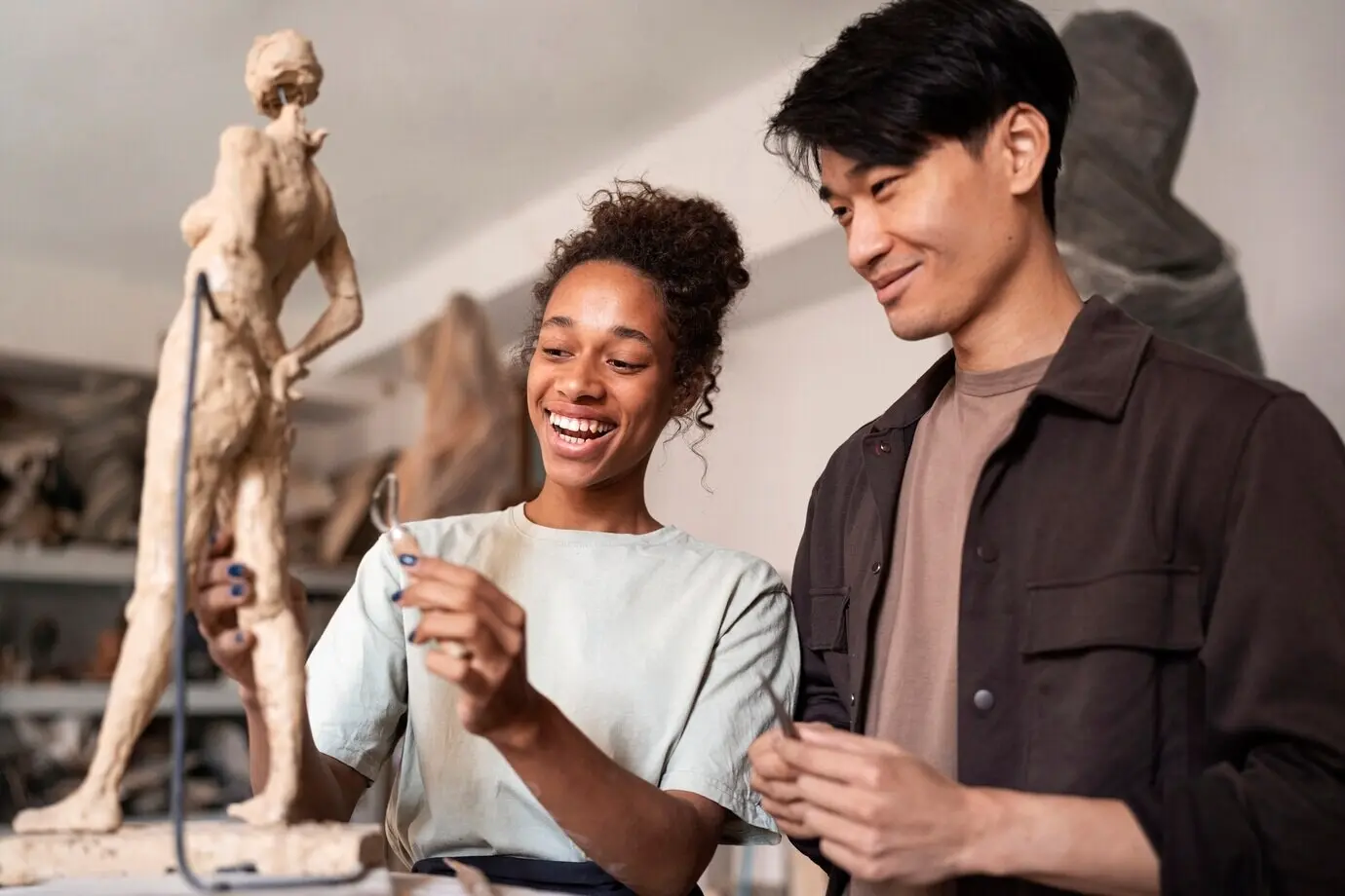 ミディアムショットで、笑顔の人々が粘土彫刻をしている